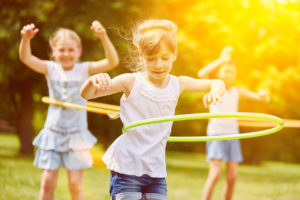 Glückliche multikulturelle Gruppe Kinder spielt im Sommer