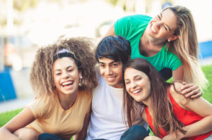 Group of happy teenagers in the park having fun spending time